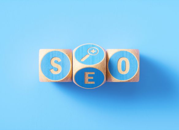 "SEO" written blue wood blocks sitting over blue background. Horizontal composition with copy space. SEO concept.